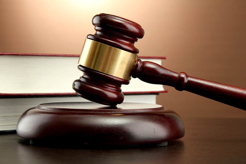 Common Personal Injury Terms & Claims - wooden gavel and books on wooden table, on brown background